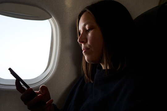 A woman uses phone on her flight