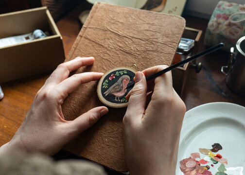 Creating a miniature bird painting on wood