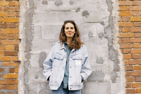 portrait of androgynous woman in front of the grey wall