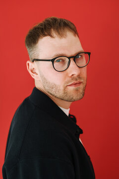 Serious Portrait of Man in Black Jacket on Red