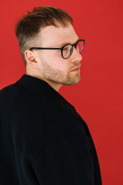 Portrait Confident Man in Glasses on Red Backdrop
