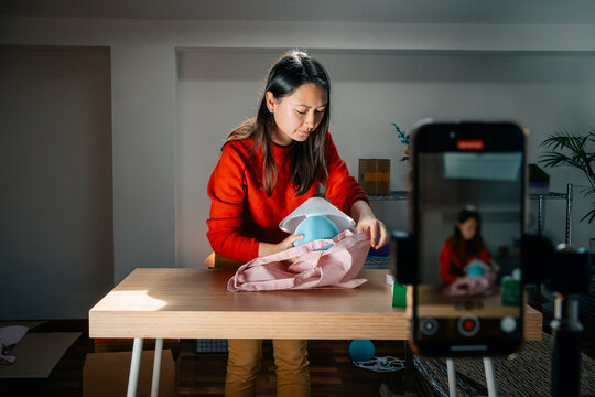  A person wraps lamp in fabric at wooden table