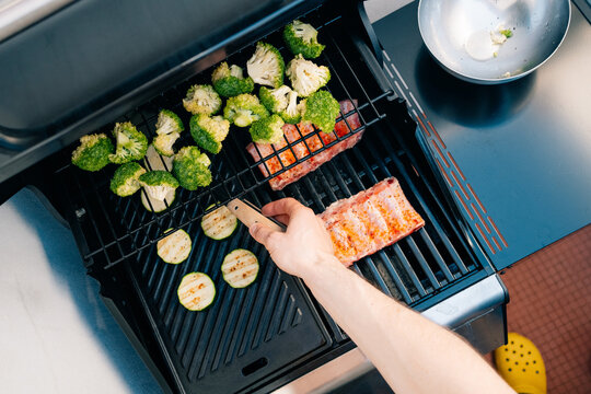 Grilling ribs and vegetables on outdoor barbecue grill