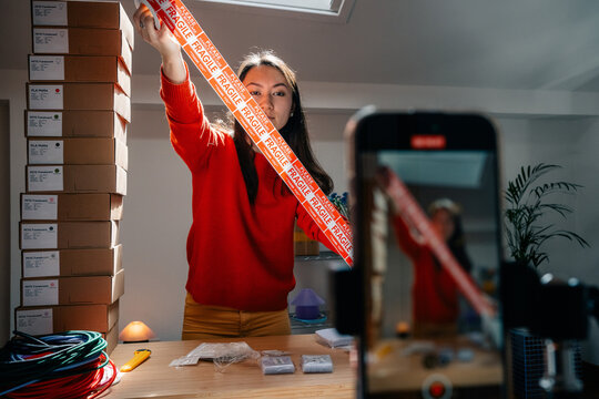 A person displays fragile tape in front of smartphone camera