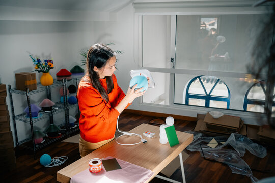 Person assembling lamp components in modern studio workspace