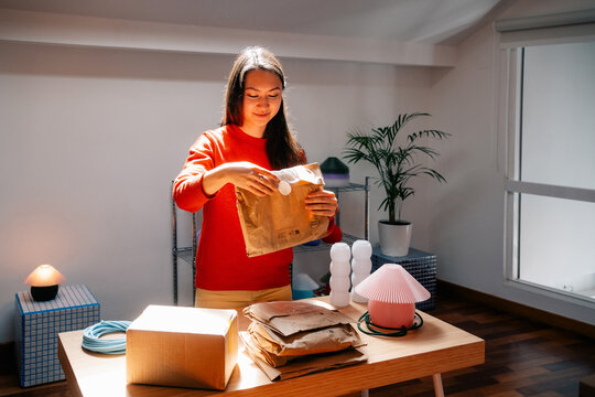 Woman holds paper pouch in bright studio light