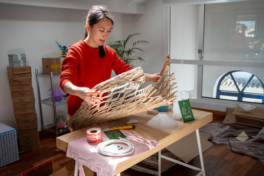 Woman arranges paper mesh for packaging on table