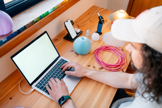 Man types beside filament and lamp shell on desk