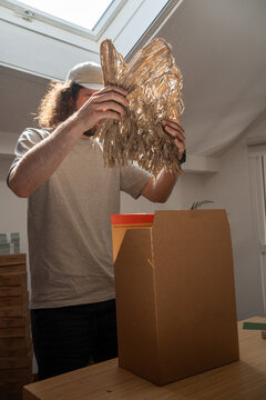 Man packs shredded filler under skylight beam