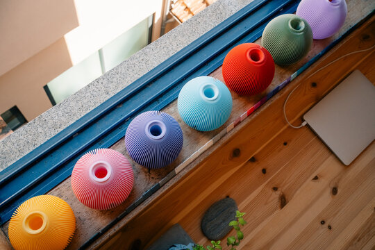 Colorful vases arranged on window ledge indoors