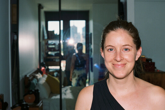 Film photo with flash of a woman smiling in a bedroom