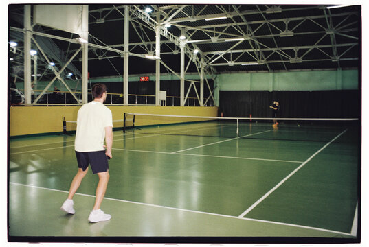 Tennis Players Competing in Indoor Court 
