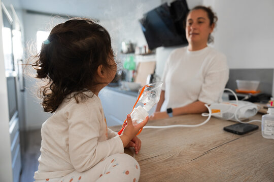 Little girl holding nebulizer mask