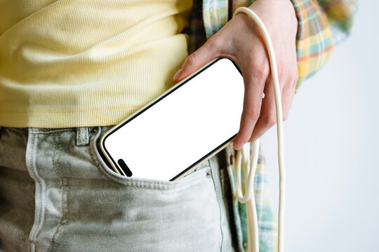 A mobile phone with white screen in woman's pocket
