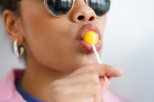 A woman sucks a lollipop