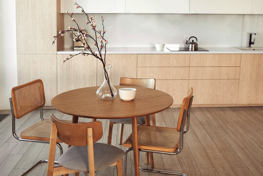 Modern kitchen interior featuring a round wooden table with chairs