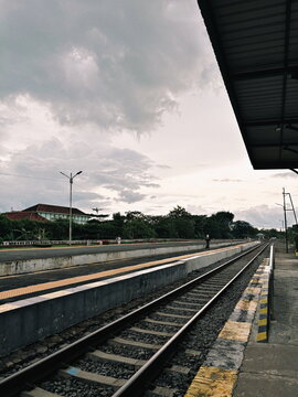 Train Tracks and Platform Under Cloudy Skies