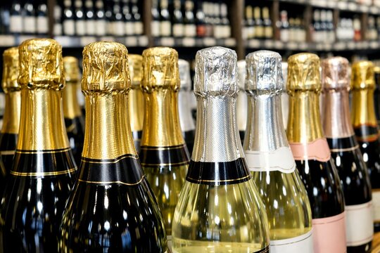 Bottles of champagne with gold and silver foil in a liquor store