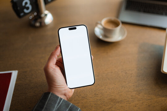 A businesswoman uses a mobile phone with white screen