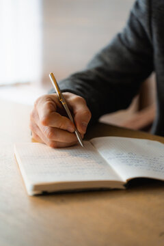 A man writes in a notebook