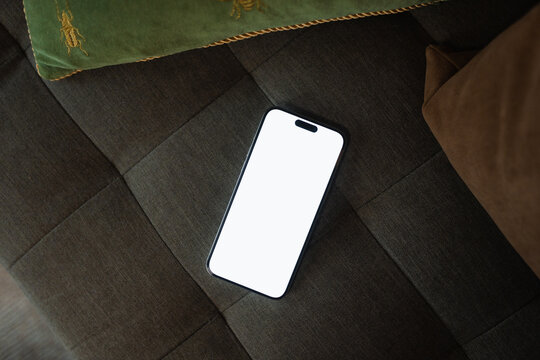 A mobile phone with white screen on the sofa