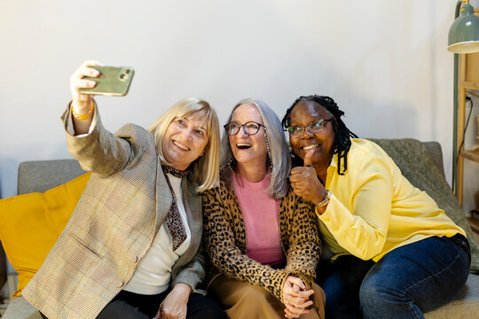 three female friends taking a selfie on smartphone