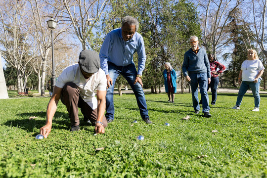 Diverse group of Senior friends Checking bocce score in park