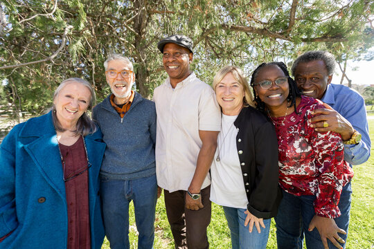 Group photo of diverse group of senior friends in park