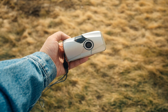 Hand holding a vintage camera outdoors