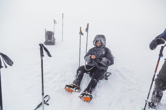 Adventurer rests in snowy conditions during mountain expedition