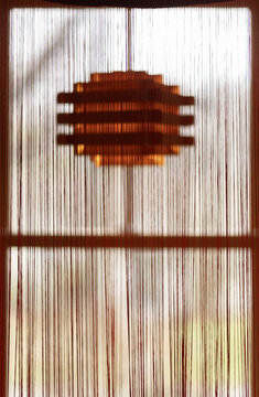 Wood chandelier behind string curtain 