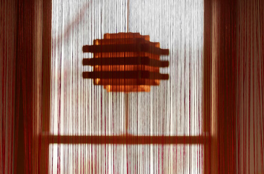 Balsa wood chandelier behind string curtain 