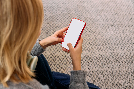 Woman wearing headphones using her phone at home