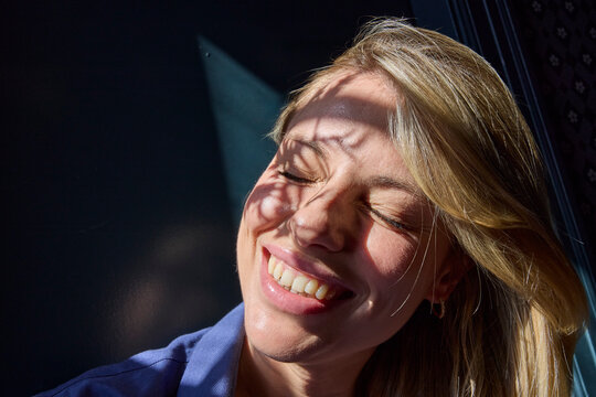 Woman soaking up window sun 