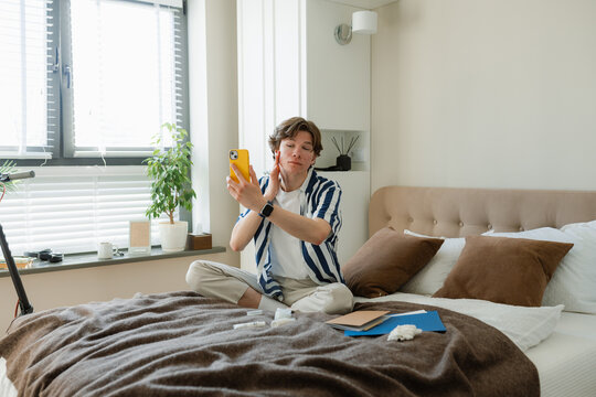 A man with acne takes selfie on a mobile phone