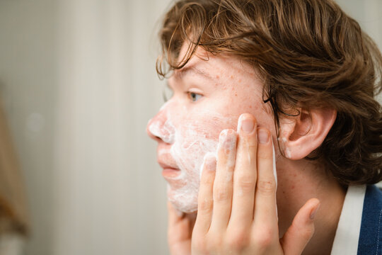 A man washes his face with foam