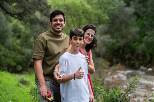 Happy family hiking in nature making thumbs up sign
