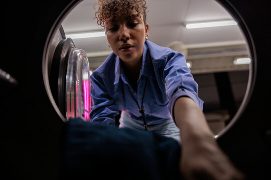 Office worker taking laundry out of machine