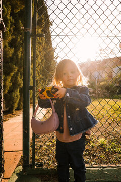 Child holding camera at gate