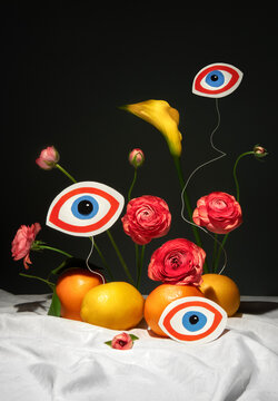 Abstract still life with citrus fruit, eyes and flowers