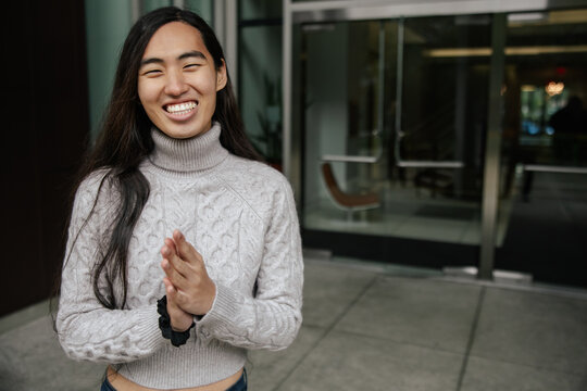 Smiling Individual Outdoors Near Office Building Entrance