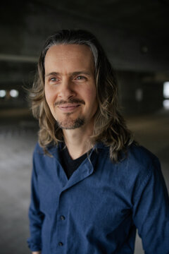 Portrait of a Long-Haired Individual in a Casual Blue Shirt Indoors