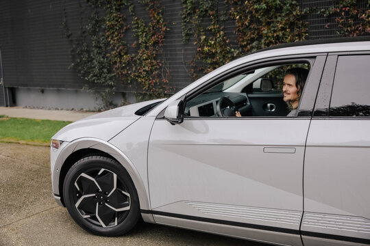 Man Driving Modern Electric Car in Urban Environment