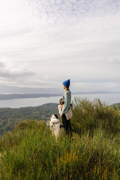 Woman at the summit of a hike with faithful dog