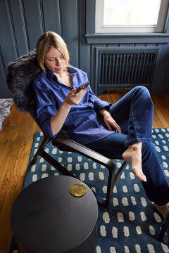 Young woman lounges in her chair at home 
