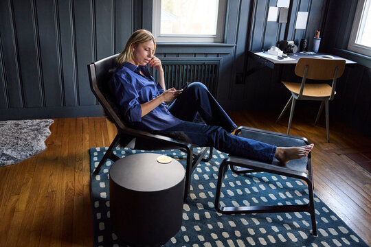 Young woman lounges in her chair at home 