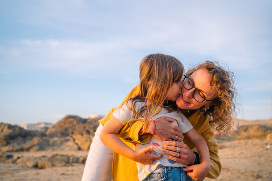 Child giving a kiss at golden hour