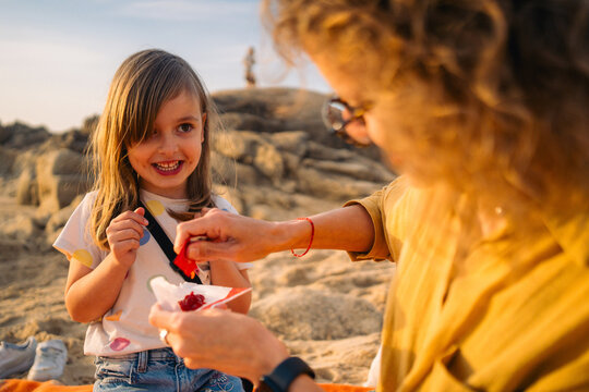 Smiling girl watches ketchup being poured