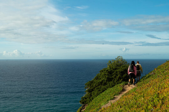 A colourful couple walking down a trail to beach