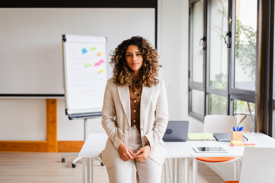 Beautiful businesswoman leans on a desk